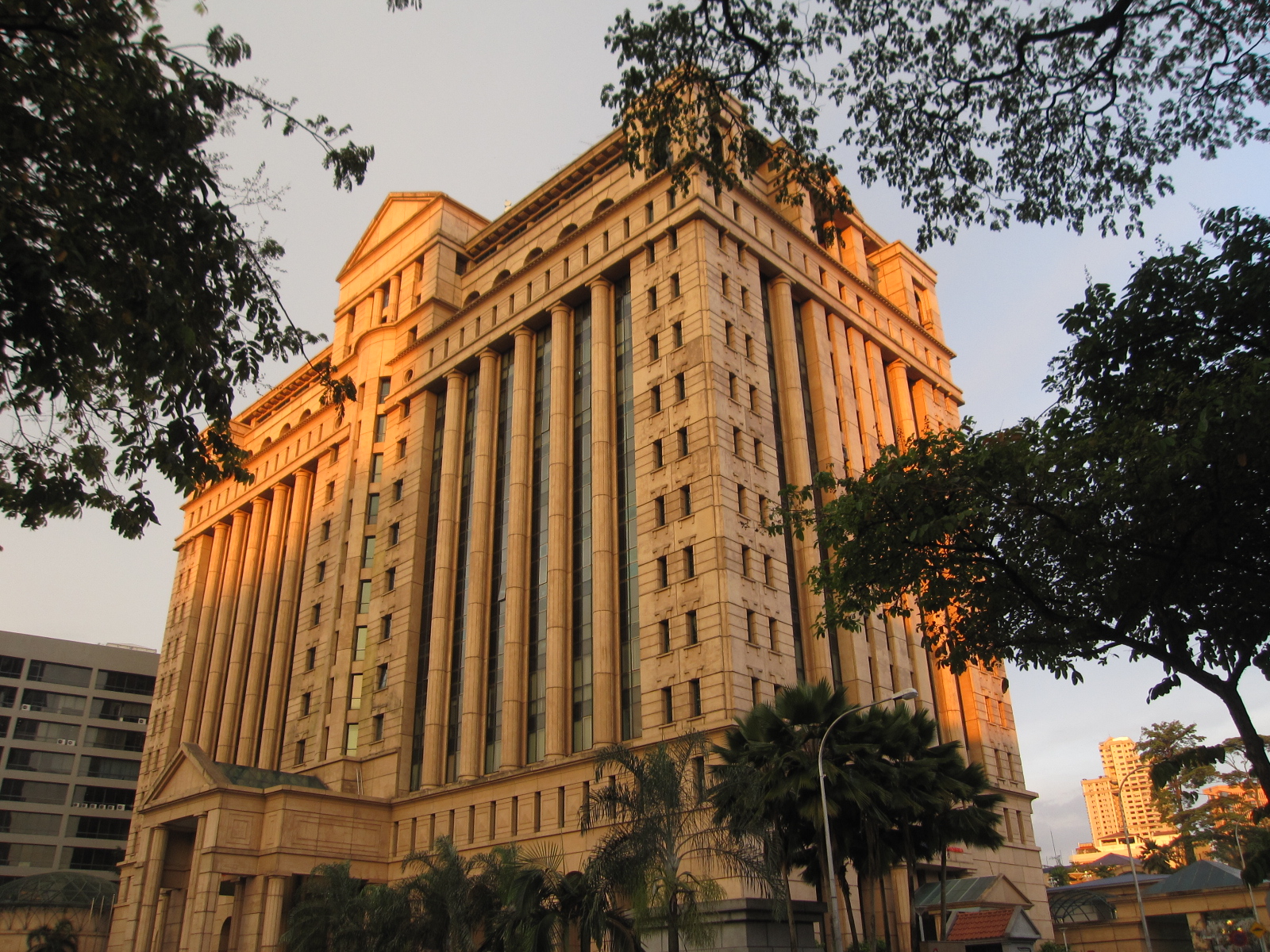 The Bursa Malaysia exchange building in Kuala Lumpur, framed by trees at dusk